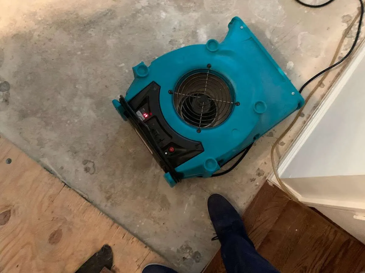 Air mover drying subfloor during Commercial Water Damage Restoration in North Syracuse